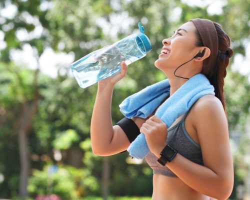 happy-sportswoman-drinking-water-park_1098-19542