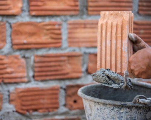 masonry-worker-outside-wall-with-trowel-knife_1150-13620